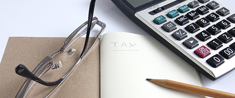 TaxEstimator Calculator, notebook, eyeglass and pencil for calculate tax